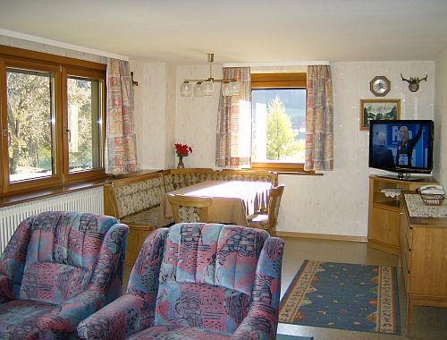 Tischbereich des Wohnzimmers mit Eckbank und TV